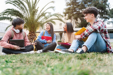 Teenagers laughing on the grass after school